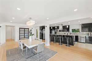 Dining room featuring wine cooler, recessed lighting, and light wood-style flooring
