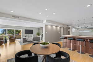 Dining room with recessed lighting, light wood finished floors, and stairway