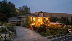 View of front facade with stucco siding, driveway, a mountain view, and a garage