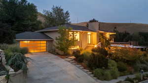 View of front of house featuring stucco siding, driveway, an attached garage, and a mountain view
