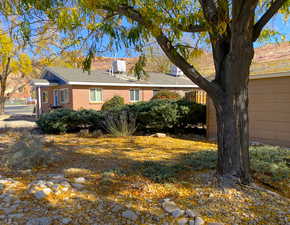 View of property exterior with brick siding and roof with shingles
