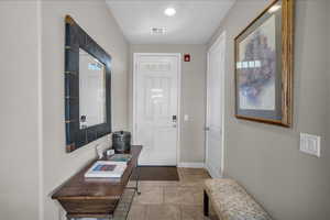 Entryway featuring light tile patterned flooring and baseboards