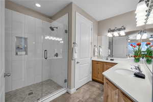 Full bathroom with a stall shower, double vanity, and light tile patterned floors