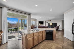 Kitchen featuring recessed lighting, black dishwasher, light countertops, a kitchen island with sink, and open floor plan