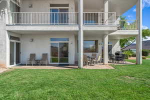 Rear view of house featuring a patio, stucco siding, and a yard