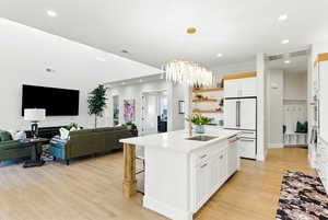 Kitchen featuring recessed lighting, white appliances, light countertops, light wood finished floors, and a chandelier