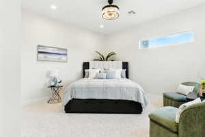 Large, carpeted bedroom with baseboards and recessed lighting.