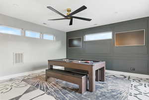 Playroom with plenty of natural light, a ceiling fan, a decorative wall, and tile patterned flooring leading to the large wrap around deck.