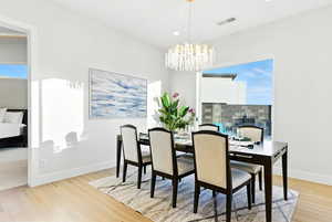 Dining room featuring light wood-style floors, a chandelier, and recessed lighting