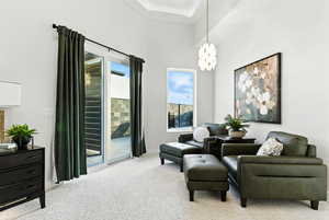 Sitting room with light colored carpet and a chandelier located in the primary bathroom. The slider leads to an outdoor shower and patio off of the back yard pool patio.