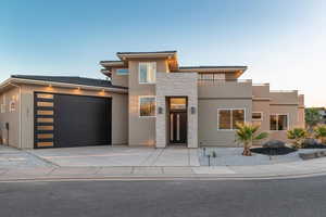 View of front of property featuring stucco siding, stone siding, a garage, concrete driveway, and a tile roof
