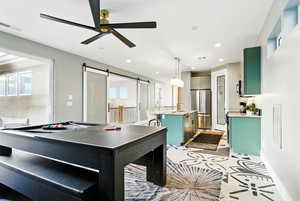 Playroom with ceiling fan, a barn door, recessed lighting, and light tile patterned floors