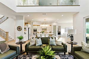 Living room featuring stairway, recessed lighting, light wood finished floors, and a towering ceiling