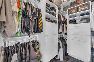 Spacious closet with dark wood-style flooring