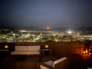 Patio at twilight featuring a patio area, a mountain view, and a view of city lights