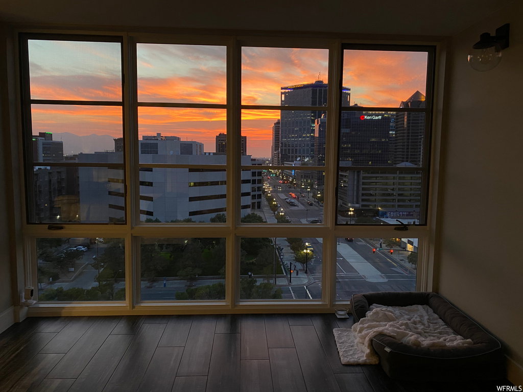 Doorway featuring a wall of windows, wood finished floors, and a city view
