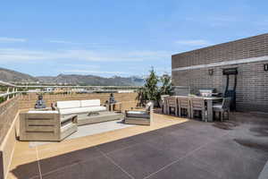 View of patio with an outdoor living space, a mountain view, and grilling area