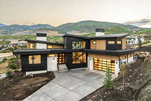 Contemporary house with a chimney, a mountain view, and concrete driveway