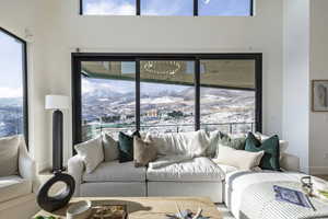 Living area with healthy amount of natural light, a towering ceiling, and a mountain view
