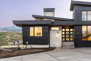 Property entrance with stone siding, french doors, and a chimney