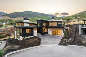 Contemporary house with a chimney, a mountain view, concrete driveway, and a garage
