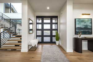 Foyer with light wood finished floors, stairs, and recessed lighting