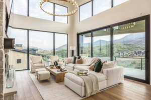 Living area featuring a mountain view, a chandelier, wood-type flooring, and a high ceiling