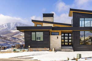 View of front facade featuring a mountain view, entry steps, and a chimney