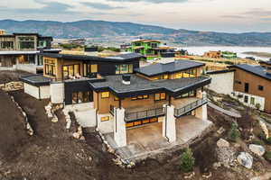 View of front of property with a patio, a mountain view, a chimney, a standing seam roof, and a metal roof
