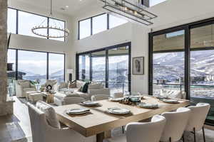 Dining room with a chandelier, a mountain view, a high ceiling, and hardwood / wood-style flooring