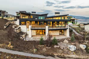 Rear view of property featuring a chimney, a mountain view, and a balcony