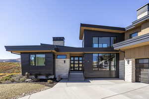 Entrance to property featuring stone siding and a chimney