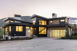 Modern home with stone siding and a chimney