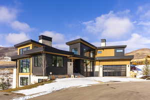 Modern home featuring a chimney, a mountain view, and an attached garage