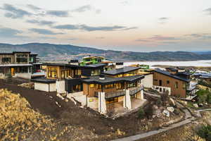 View of front of property with a mountain view, a chimney, a patio, and a balcony