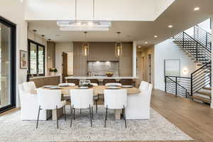Dining space with stairs, recessed lighting, and light wood-style flooring