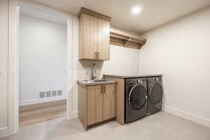 Washroom featuring washer and clothes dryer and cabinet space
