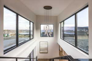 Stairs featuring a chandelier, a water and mountain view, plenty of natural light, and wood finished floors