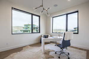Home office featuring a chandelier and wood finished floors