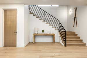 Stairs with wood finished floors and baseboards