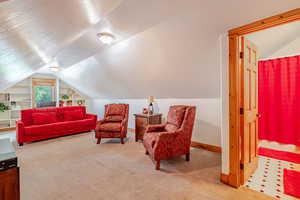 Loft with vaulted ceiling and carpet floors