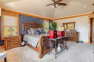 Master Bedroom with vaulted ceiling, ornamental molding, carpet floors, and ceiling fan