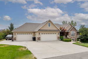 View of front of house with stucco siding, concrete driveway, stone siding, an attached garage, and a shingled roof