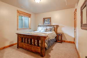 Bedroom with light colored carpet and baseboards