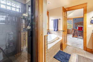 Full bathroom featuring a garden tub and tile patterned flooring