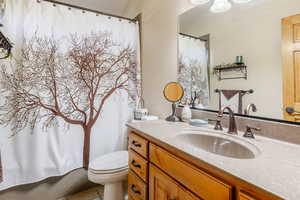 Full bath featuring vanity, light tile patterned floors, and a shower with shower curtain