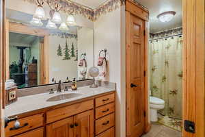 Bathroom with vanity, light tile patterned floors, and a shower with curtain