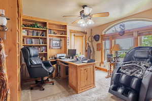 Home office featuring light colored carpet, healthy amount of natural light, and a ceiling fan
