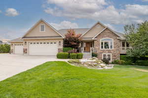 Craftsman-style home with stone siding, stucco siding, and a front yard