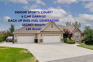 View of front of home with stucco siding, stone siding, and concrete driveway